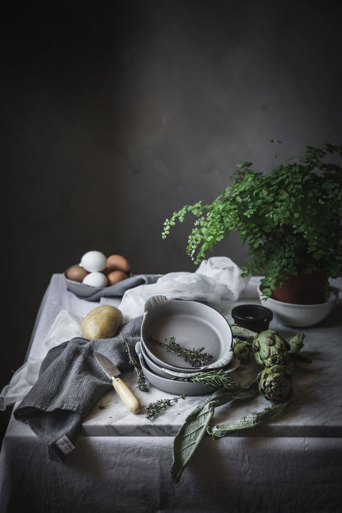 Eggs and different herbs in bowls placed on rustic table