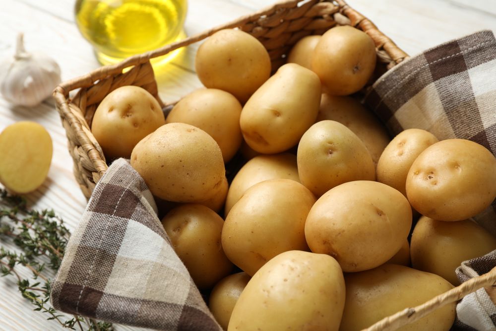 Wicker box of potatoes wrapped in kitchen towel
