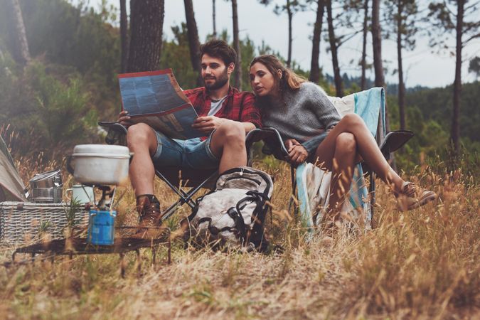 Adventurous young couple camping in the forest