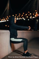 Side view of a young fit woman doing wall squat in the evening be6d60
