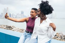 Stylish friends taking selfies along the boardwalk in Panama City
