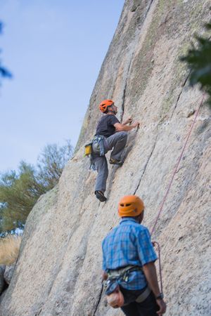 Climbers in safety harness climbing mountain