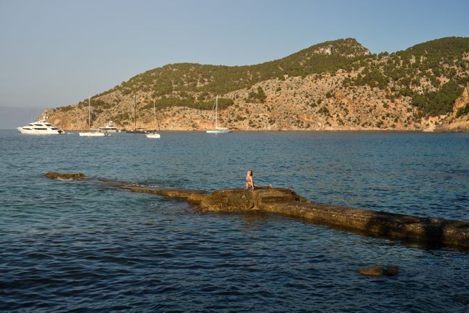 Woman doing yoga on rocky pier