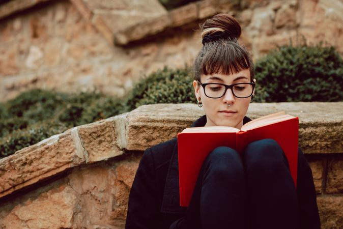 Young woman reading book on steps