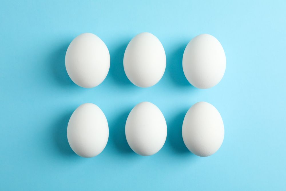Flat lay composition with chicken eggs on color background, space for text