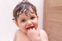 Baby biting fingers in bathroom