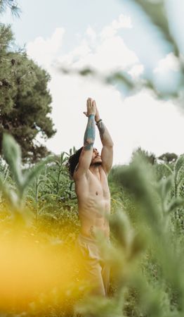 Man training meditating on meadow