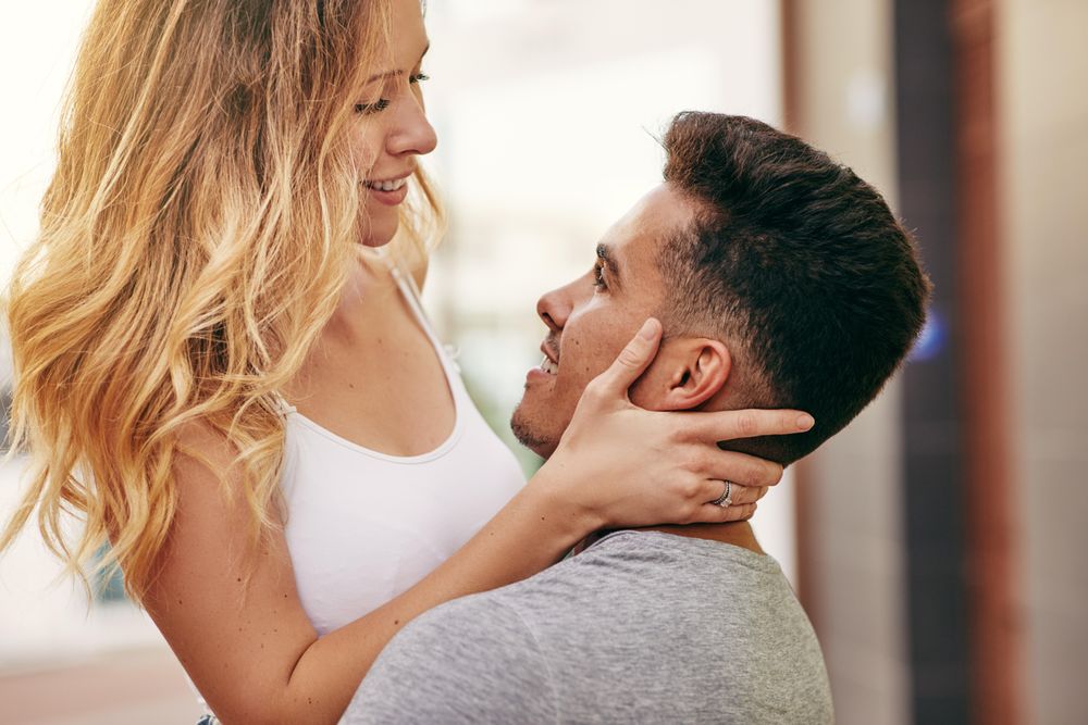 Man holding woman as they stare into each others eyes