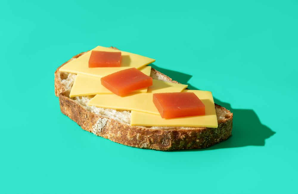 Slice of bread with cheese and marmalade isolated on a blue background