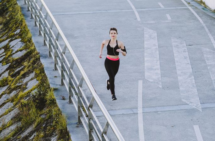 Woman running on embankment near water