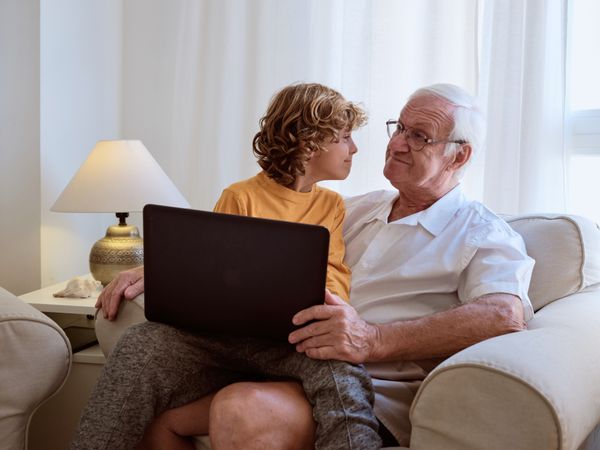 Content grandfather and grandson with laptop
