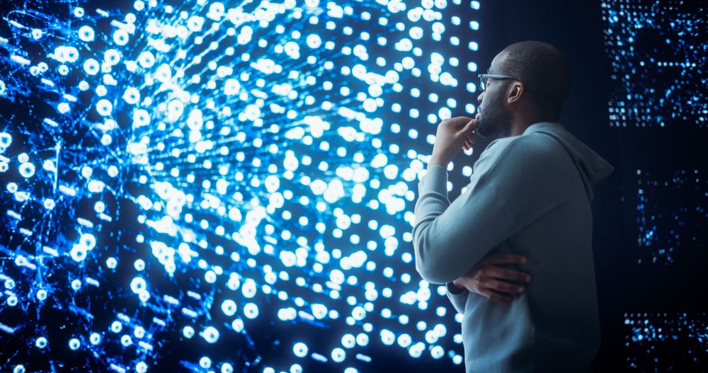 Black Young Man Looking at a Big Screen with Neural Network Visualisation In 3D.