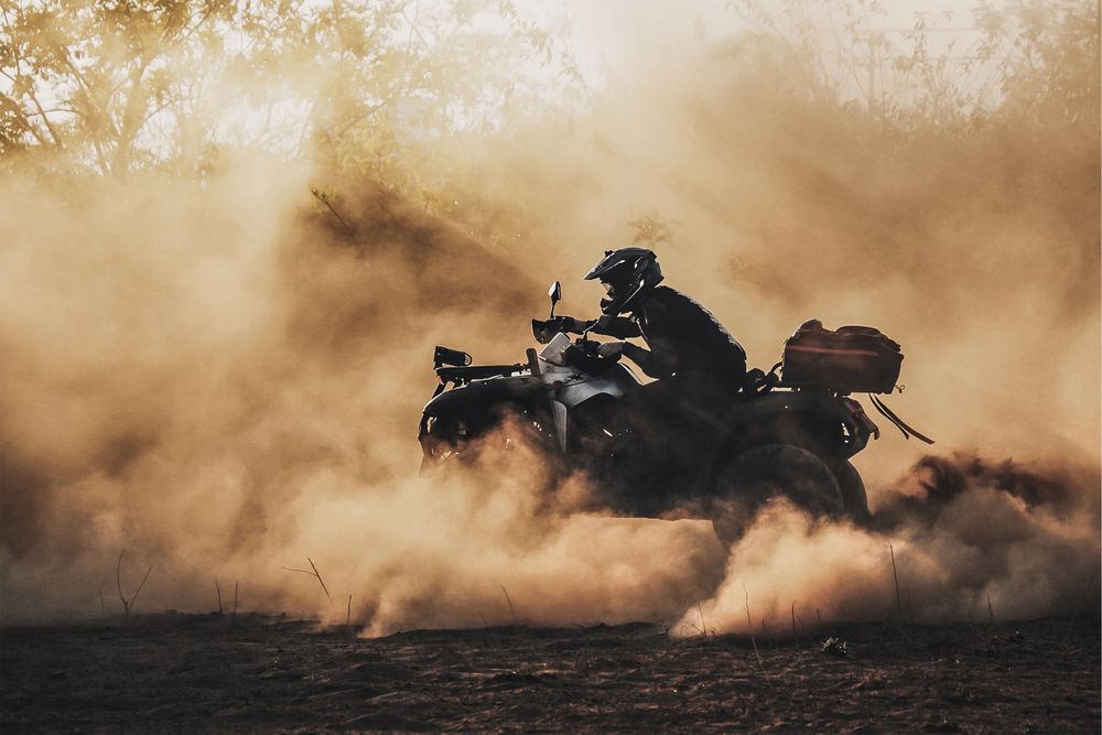 Person with helmet riding an ATV