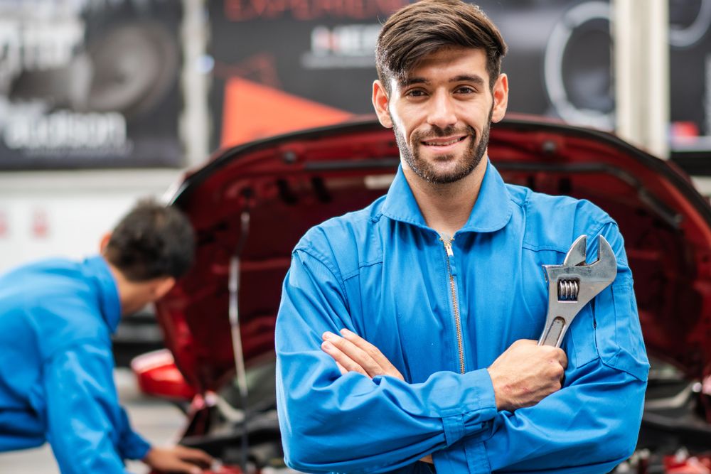 Portrait of automotive mechanic man holding wrench