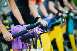 Group of people working out on stationary bikes at spinning class in gym