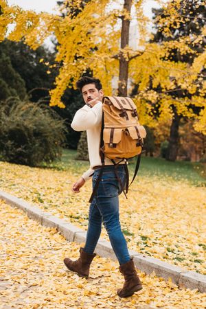 Trendy young male walking on park