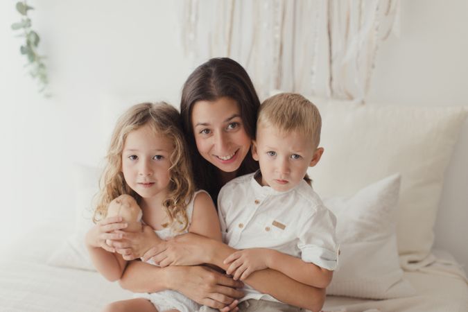 Content young mother with little kids at bedroom