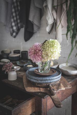 Table with set of flowers in glasses in room