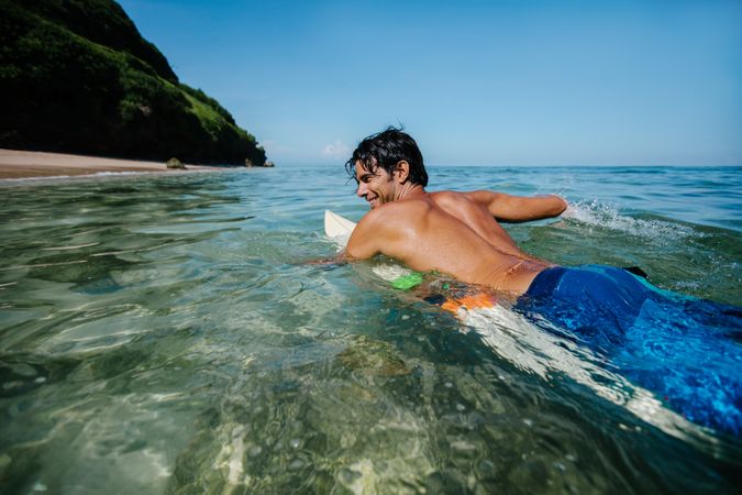 Male surfer in the ocean water with surf board