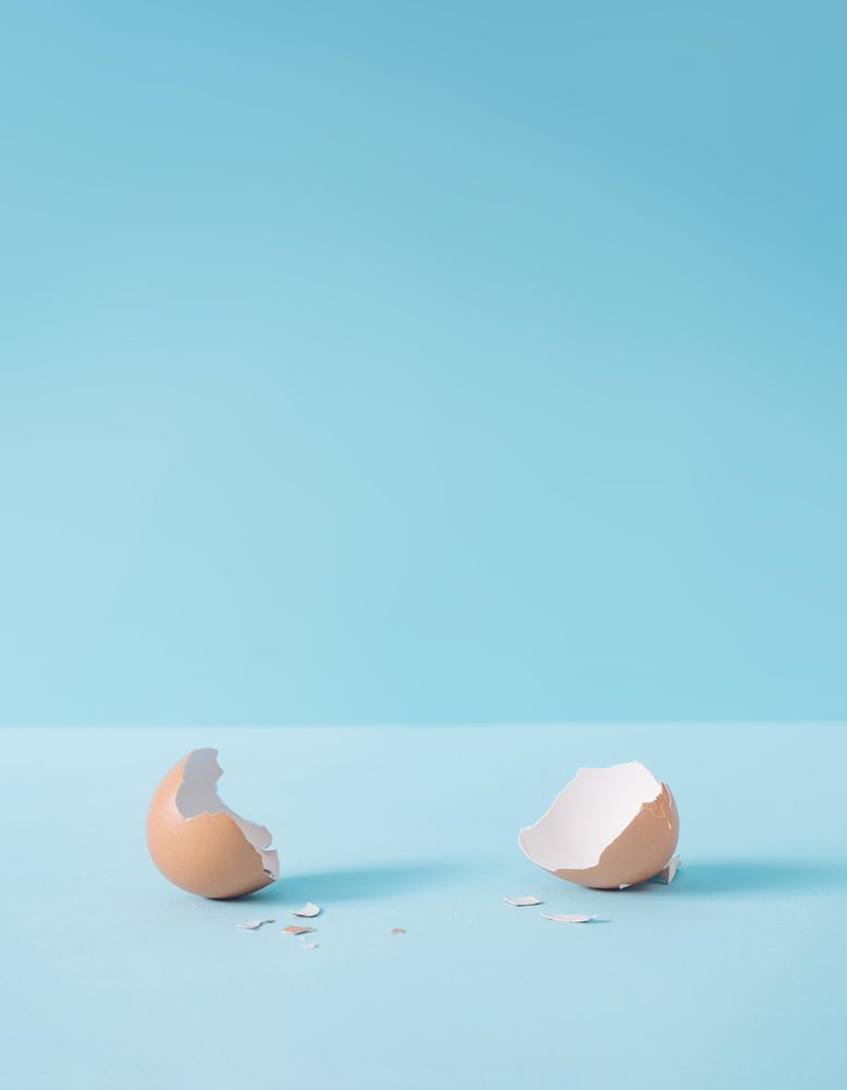 Empty eggshell with creative copy space on pastel blue background
