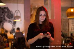 Woman checking phone in cafe 4MO9E0
