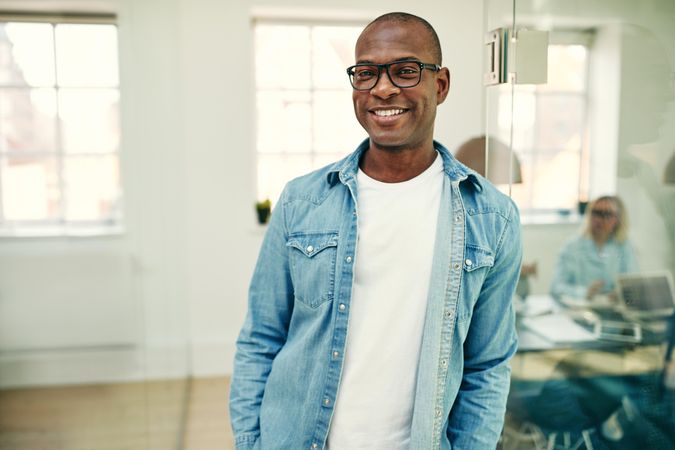 Portrait of man in jean shirt in a bright modern office