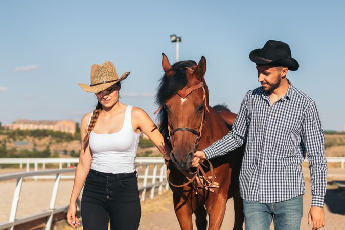 Friends walking with a horse in an equestrian center