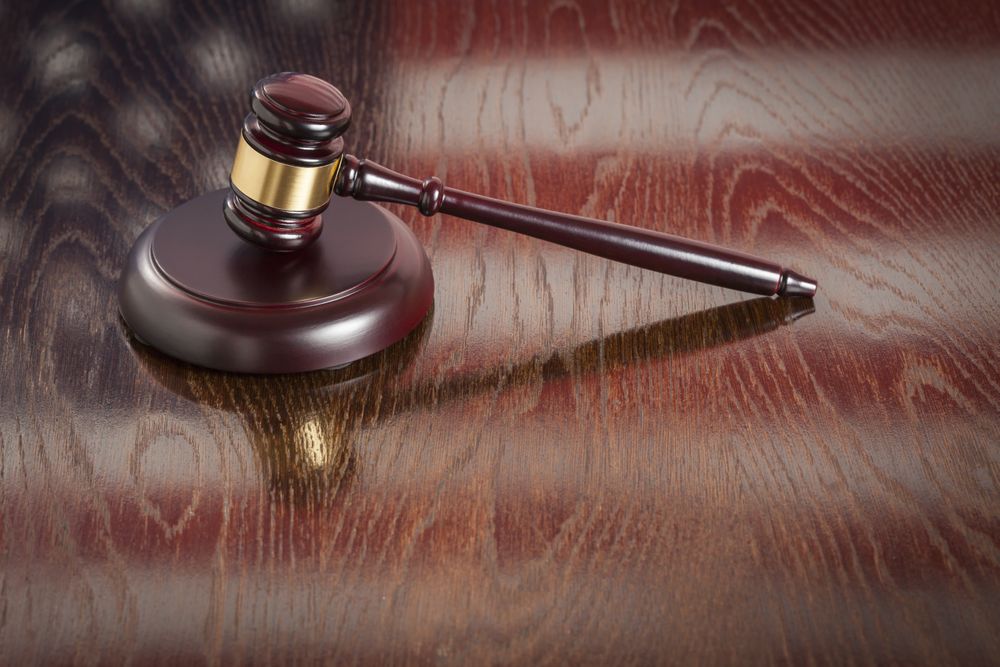 Wooden Gavel Resting on Flag Reflecting Table