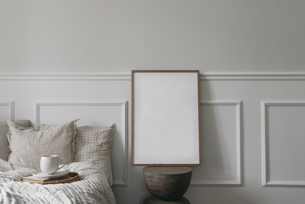 Bed with tray of coffee and blank picture frame