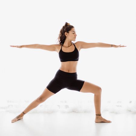 Sportive woman performing yoga pose in room