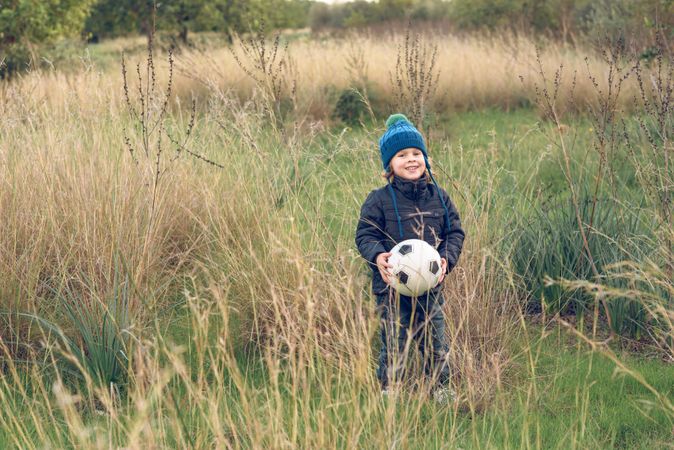 Positive boy with ball in nature