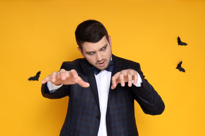Concept of Halloween, young man on yellow background