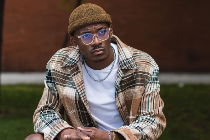 Stylish Black man resting on street