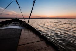 Front of boat riding along sea