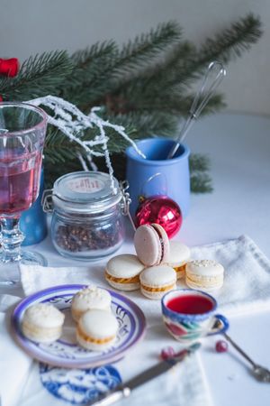 Sweet festive macarons on tablecloth with tea cup