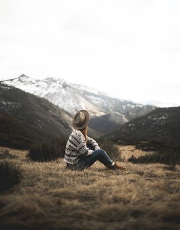 Woman relaxing on meadow with mountain landscape