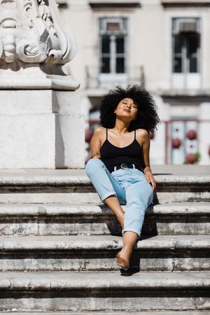 Black female sitting on stairs outdoors