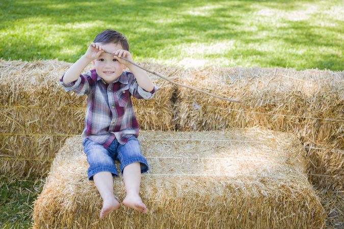 Cute Young Boy Having Fun on Hay Bale