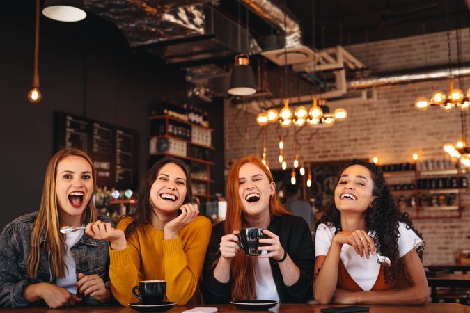 Cheerful young women sitting at coffee shop