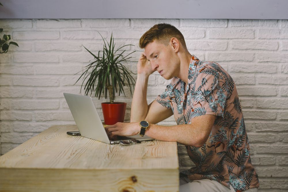 Man working on browsing laptop
