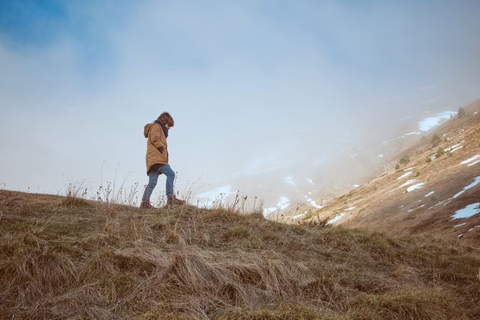 Boy walking on grassy hill