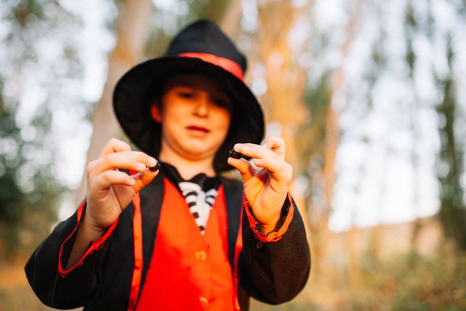 Boy in halloween costume holding berries