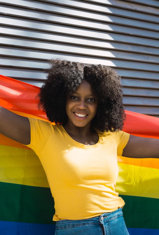 Woman posing happily with the LGBT flag