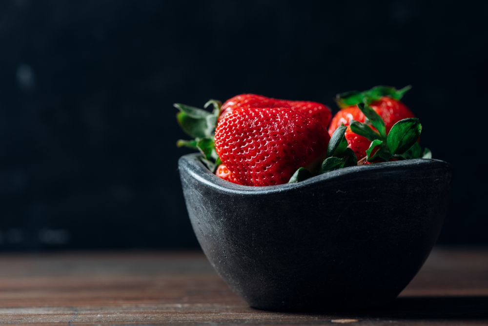 Fresh ripe strawberries in concrete bowl