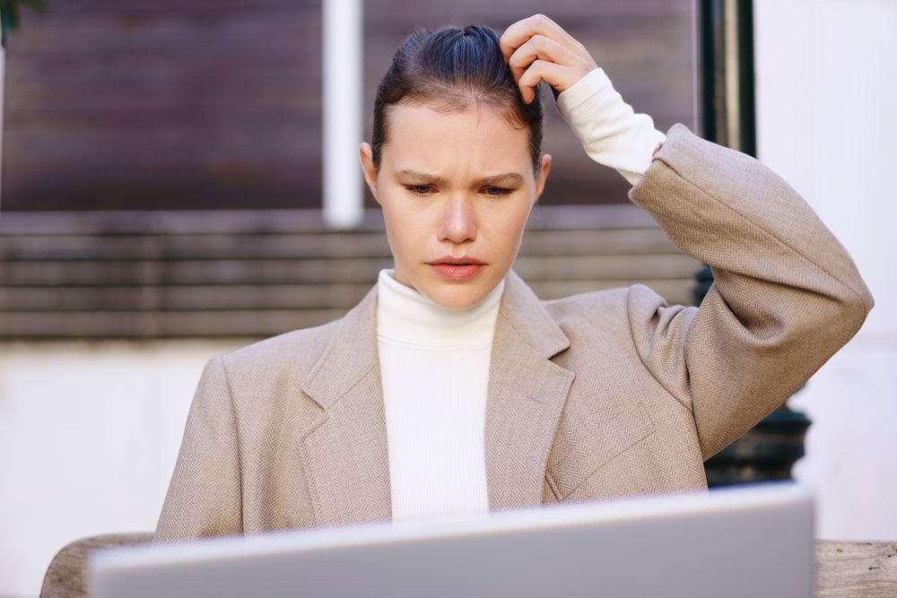 A Pensive Businesswoman is Struggling with Various Laptop Problems and Technical Issues