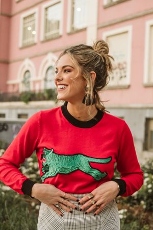 woman near flowerbed and building