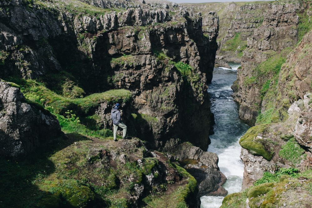 Man on edge of rugged cliff on a sunny day