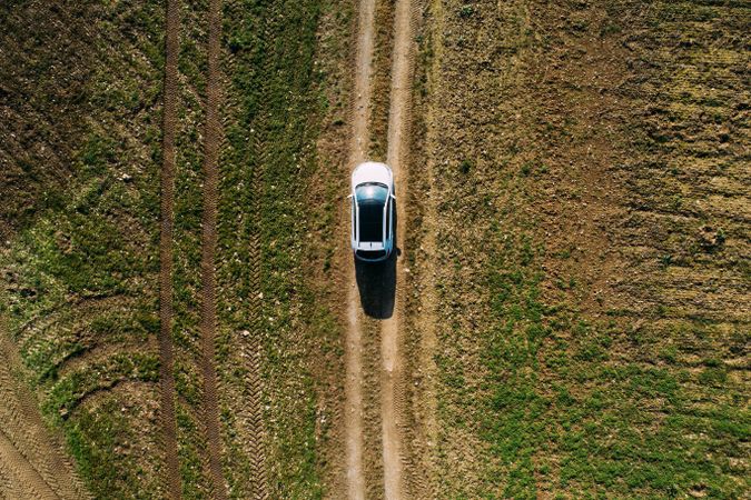 Aerial view of a car crossing a dirt road