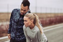 Young couple stretching before jog outdoors