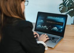Female trader typing on laptop